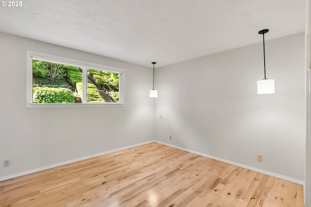 spare room featuring wood finished floors and baseboards