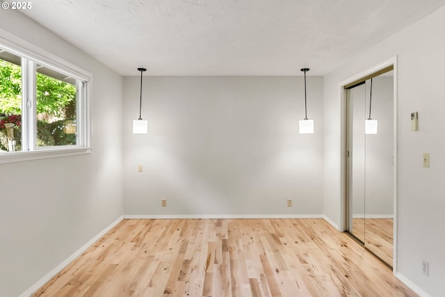unfurnished room featuring light wood-type flooring and baseboards