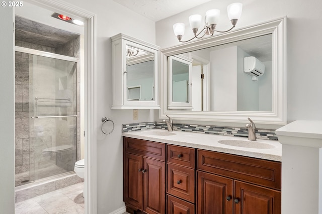 bathroom with toilet, a stall shower, a chandelier, and double vanity