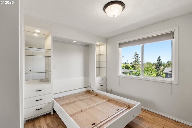 unfurnished bedroom with light wood-style flooring, baseboards, and recessed lighting