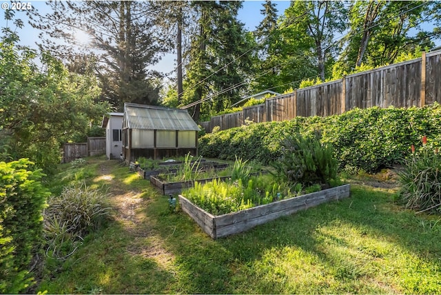 view of yard with a greenhouse, a vegetable garden, and an outdoor structure