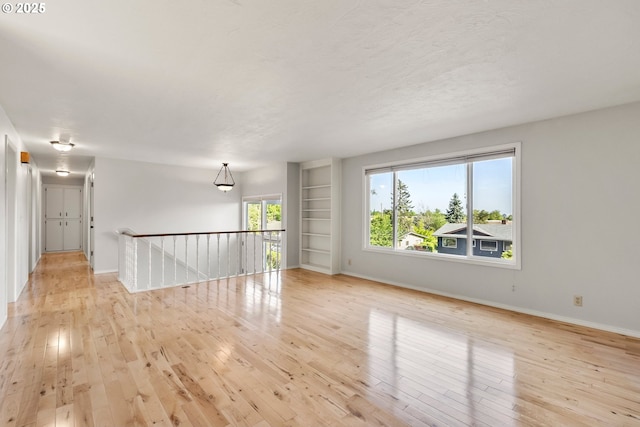 empty room with light wood finished floors and baseboards