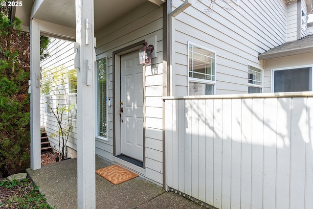 doorway to property featuring a shingled roof