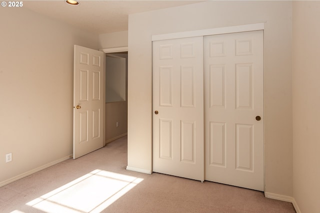 unfurnished bedroom with a closet, baseboards, and carpet flooring