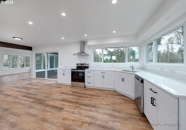 kitchen with stainless steel appliances, white cabinetry, sink, and wall chimney exhaust hood