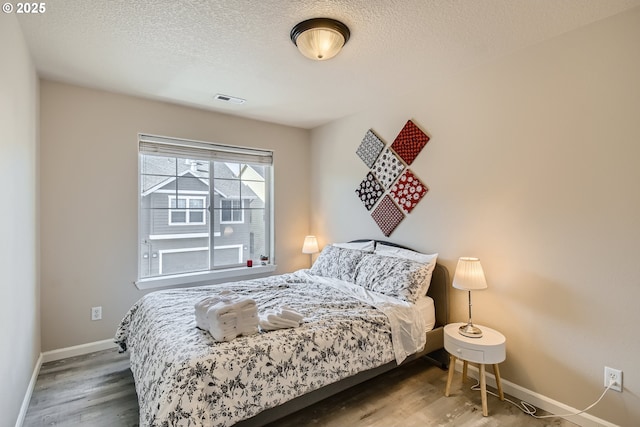 bedroom with hardwood / wood-style flooring and a textured ceiling