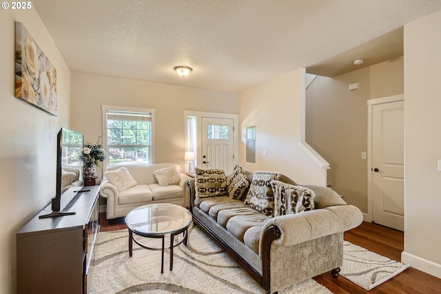 living room with wood-type flooring and a textured ceiling