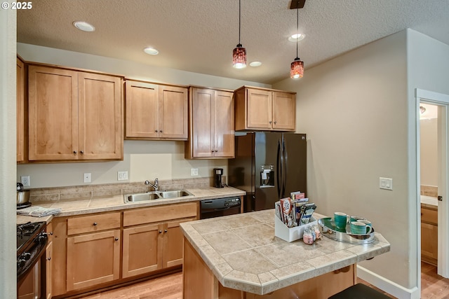 kitchen featuring hanging light fixtures, sink, light wood-type flooring, and black appliances