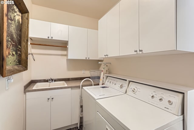 clothes washing area with washing machine and dryer and cabinet space