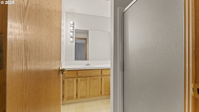 bathroom featuring tile patterned floors, a stall shower, and vanity