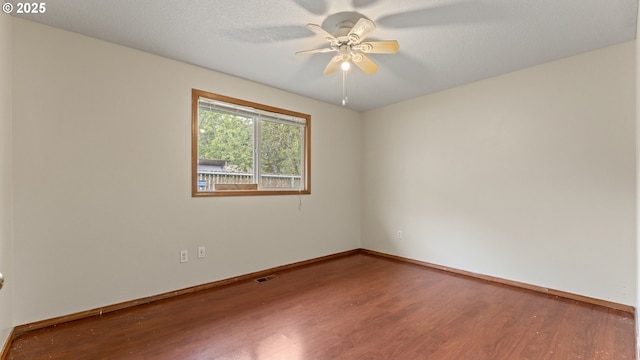 unfurnished room with wood finished floors, ceiling fan, and baseboards