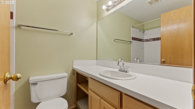 bathroom with toilet, vanity, and a shower