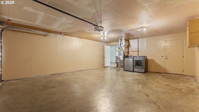 garage featuring independent washer and dryer, a garage door opener, and heating unit