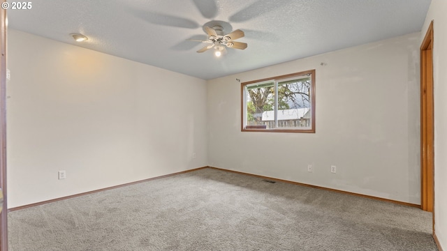 carpeted empty room featuring ceiling fan, baseboards, and a textured ceiling