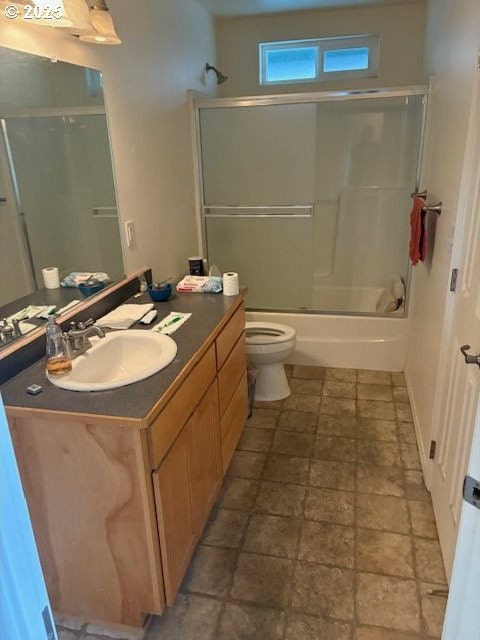 815 Old County Rd Unit 15, Brookings, OR 97415 - full bathroom featuring vanity, stone finish flooring, toilet, and bath / shower combo with glass door