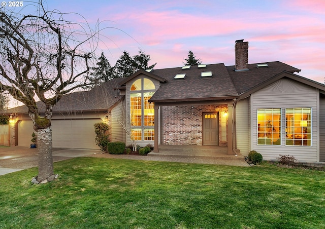 view of front of home featuring a garage and a yard