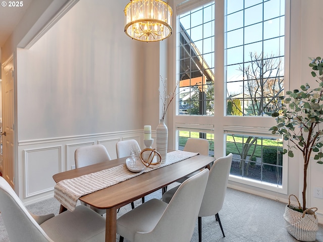 dining area featuring carpet, a towering ceiling, and a chandelier