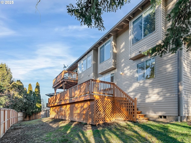 rear view of property with a wooden deck and a yard