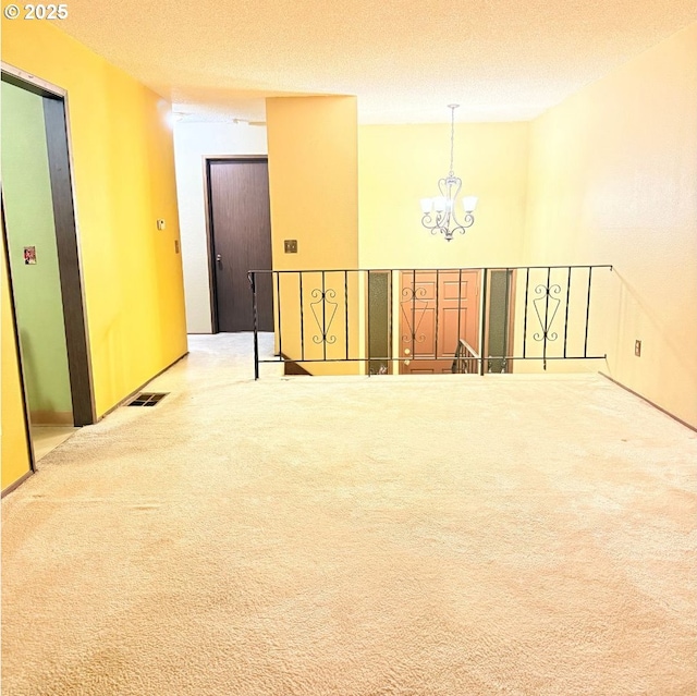 14807 NE Siskiyou Ct, Portland, OR 97230 - spare room featuring a chandelier, carpet flooring, and a textured ceiling
