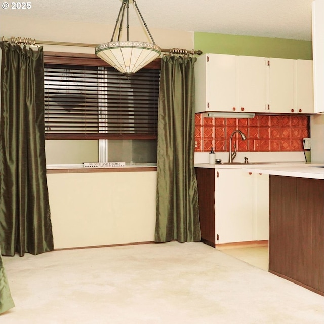 14807 NE Siskiyou Ct, Portland, OR 97230 - kitchen with a sink, white cabinetry, light countertops, light colored carpet, and backsplash