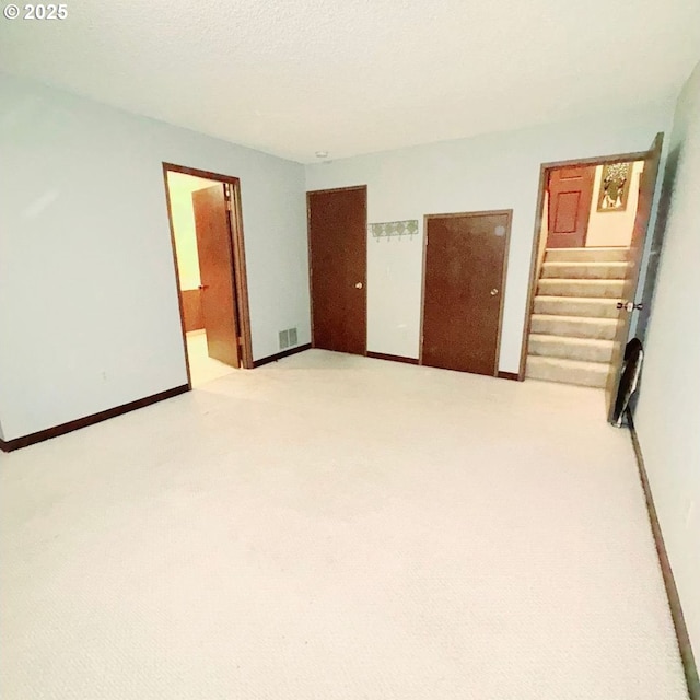 14807 NE Siskiyou Ct, Portland, OR 97230 - empty room featuring light carpet, stairway, and baseboards