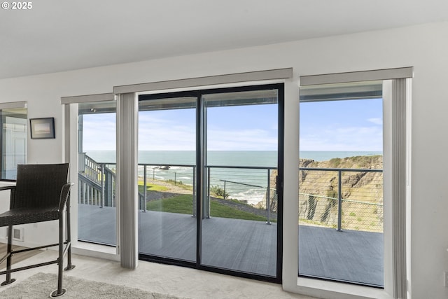 entryway featuring a water view and light carpet