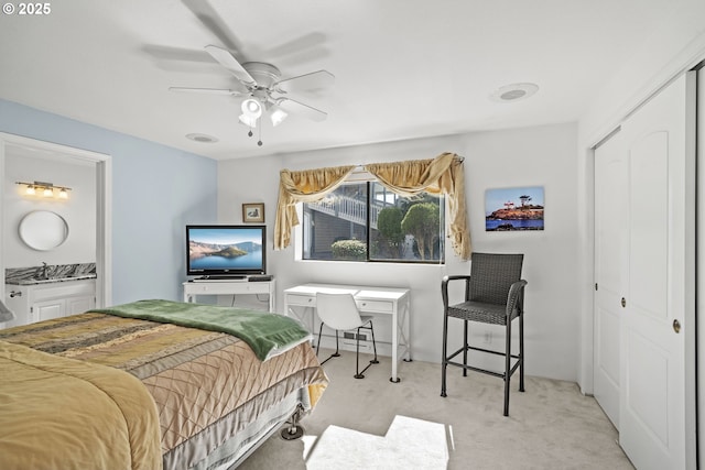 bedroom with a closet, a sink, a ceiling fan, and carpet floors