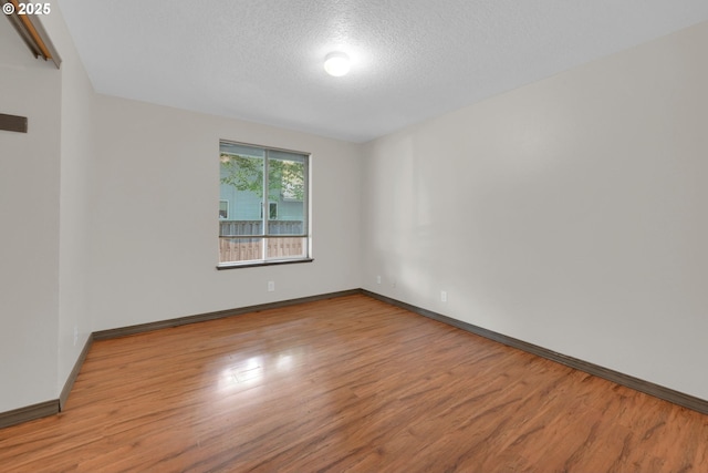815 Bobolink Ave, Eugene, OR 97404 - spare room with wood finished floors, baseboards, and a textured ceiling
