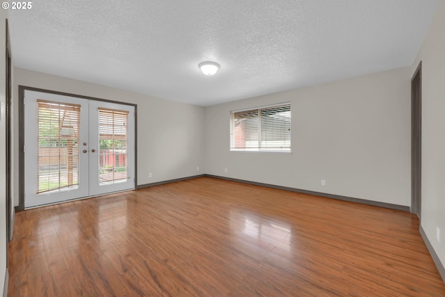 815 Bobolink Ave, Eugene, OR 97404 - unfurnished room with french doors, a textured ceiling, wood finished floors, and baseboards