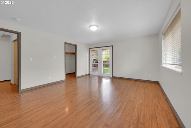 815 Bobolink Ave, Eugene, OR 97404 - unfurnished room with light wood finished floors, baseboards, and a textured ceiling