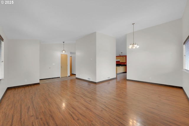 815 Bobolink Ave, Eugene, OR 97404 - unfurnished living room with wood finished floors, a chandelier, and baseboards