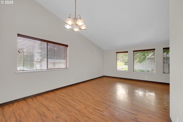 815 Bobolink Ave, Eugene, OR 97404 - spare room featuring vaulted ceiling, plenty of natural light, a chandelier, wood finished floors, and baseboards