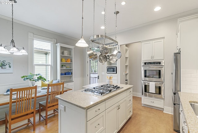2153 NE Rodney Ave, Portland, OR 97212 - kitchen featuring stainless steel appliances, ornamental molding, a kitchen island, healthy amount of natural light, and white cabinetry