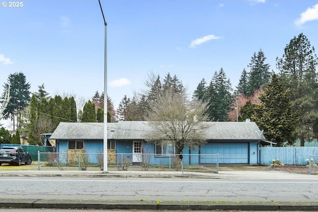 view of front of home with a fenced front yard, an attached garage, and concrete driveway