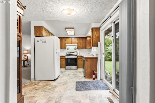 kitchen with visible vents, brown cabinets, stainless steel appliances, light countertops, and extractor fan