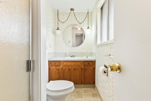 bathroom with wallpapered walls, tile patterned floors, toilet, and vanity