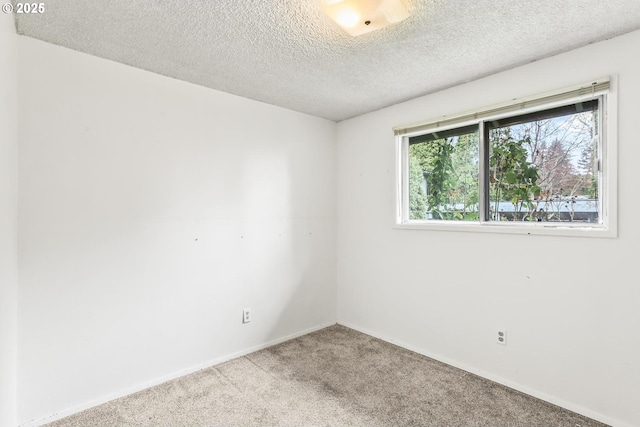 carpeted spare room featuring a textured ceiling