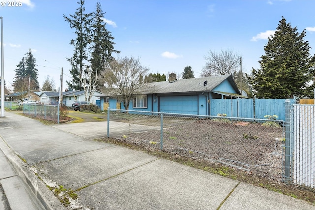 ranch-style house with driveway, an attached garage, a chimney, a fenced front yard, and a residential view