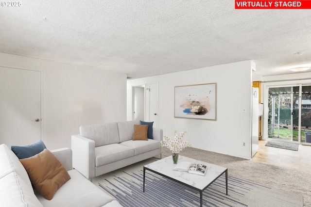 carpeted living area featuring a textured ceiling