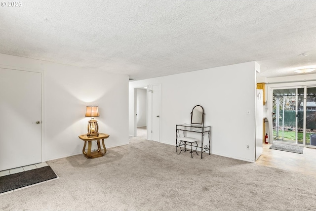 interior space featuring a textured ceiling and carpet