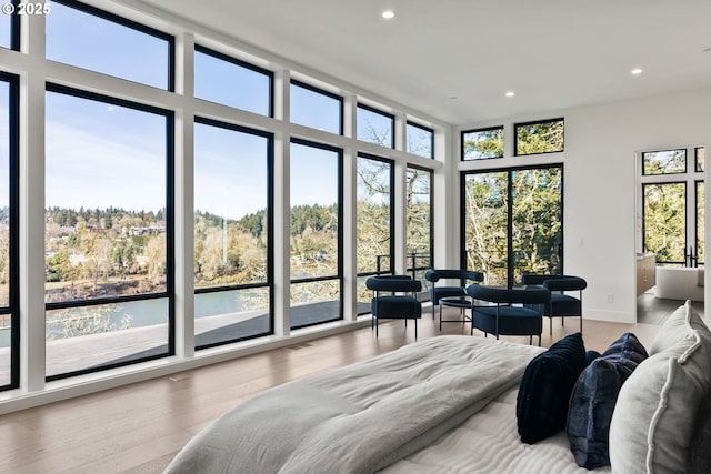 bedroom featuring a wall of windows and hardwood / wood-style floors