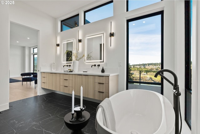 bathroom featuring vanity and a washtub