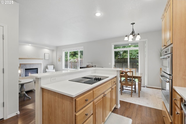 2510 NW Rogue Valley Ter, Beaverton, OR 97006 - kitchen featuring dark wood-style floors, black electric cooktop, light countertops, and a chandelier