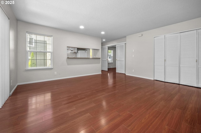 8540 SW Curry Dr Unit D, Wilsonville, OR 97070 - unfurnished living room featuring a textured ceiling, wood finished floors, recessed lighting, and baseboards