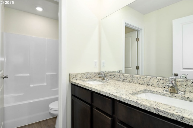 full bathroom with hardwood / wood-style flooring, vanity, toilet, and bathtub / shower combination