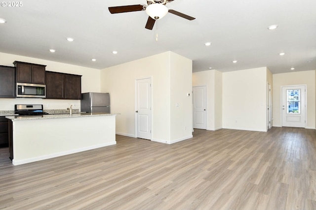 kitchen featuring dark brown cabinetry, ceiling fan, light hardwood / wood-style flooring, a center island with sink, and appliances with stainless steel finishes