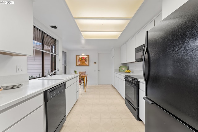 kitchen featuring white cabinetry, sink, hanging light fixtures, and black appliances