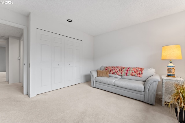 carpeted living room featuring a textured ceiling