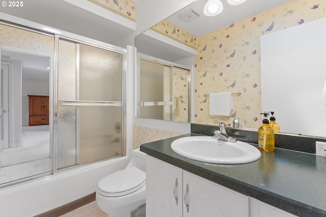 full bathroom featuring vanity, bath / shower combo with glass door, and toilet