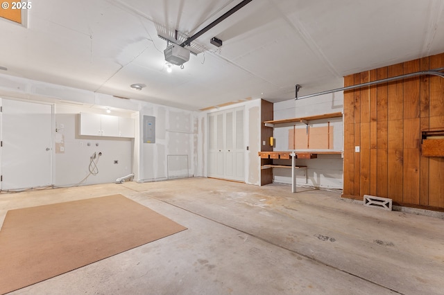 garage featuring a garage door opener, wooden walls, and electric panel